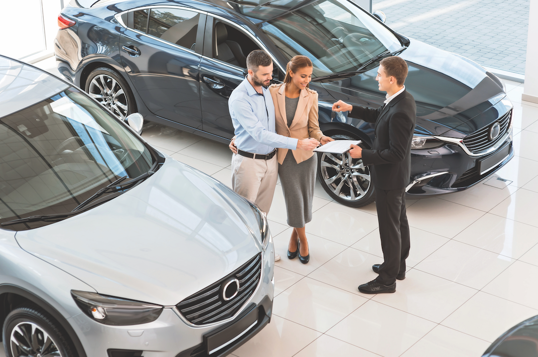 Couple Reviewing an Auto Loan in a Dealership
